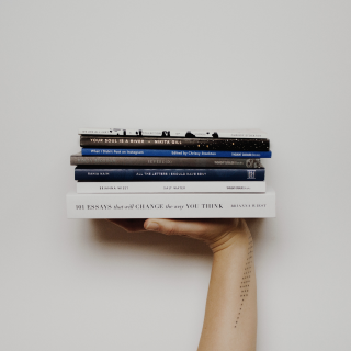 Фото руки со стопкой книг на ладони